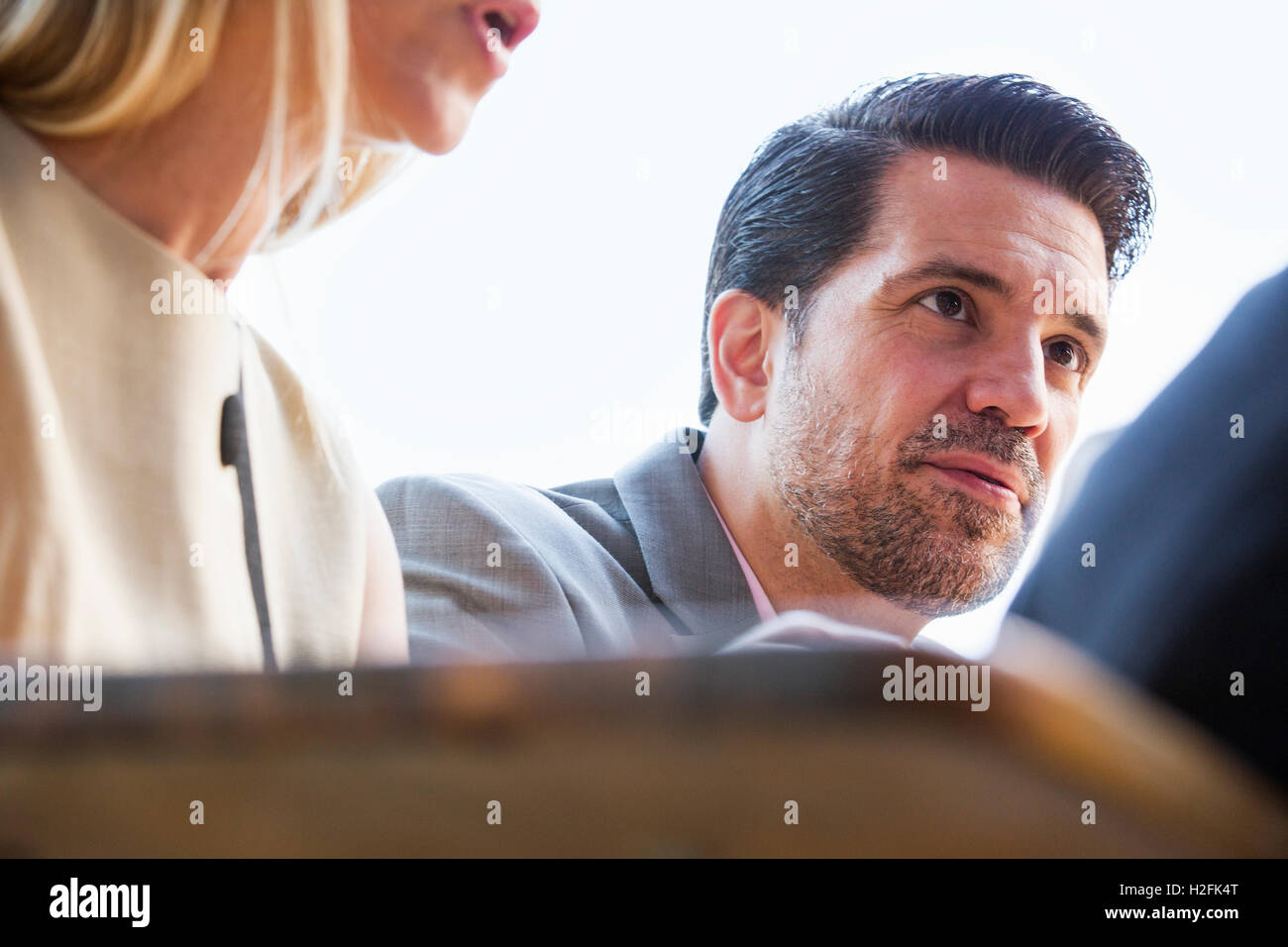 Nahaufnahme einer Unternehmerin und Unternehmer an einem Tisch sitzen. Stockfoto