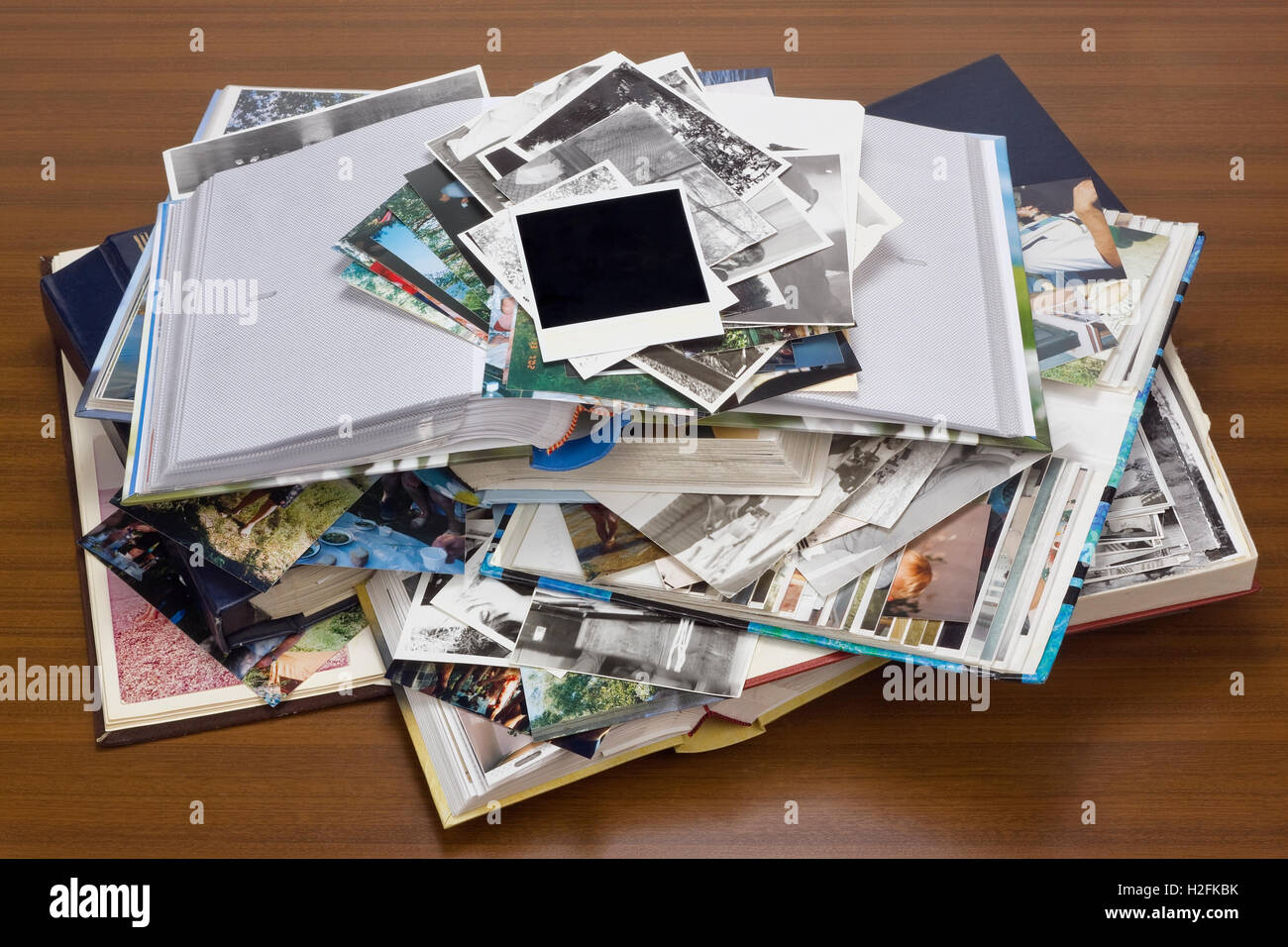 Nostalgie von Jugend - alte Familien-Fotoalben und Fotos liegen einen Haufen auf einem Holztisch. Stockfoto