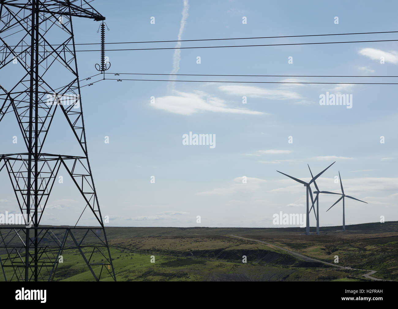 Energiemix, Strompylon mit Hochspannungsleitungen und Windturbinen im Hintergrund auf den Hügeln der Pennine Moors in lancashire uk Stockfoto
