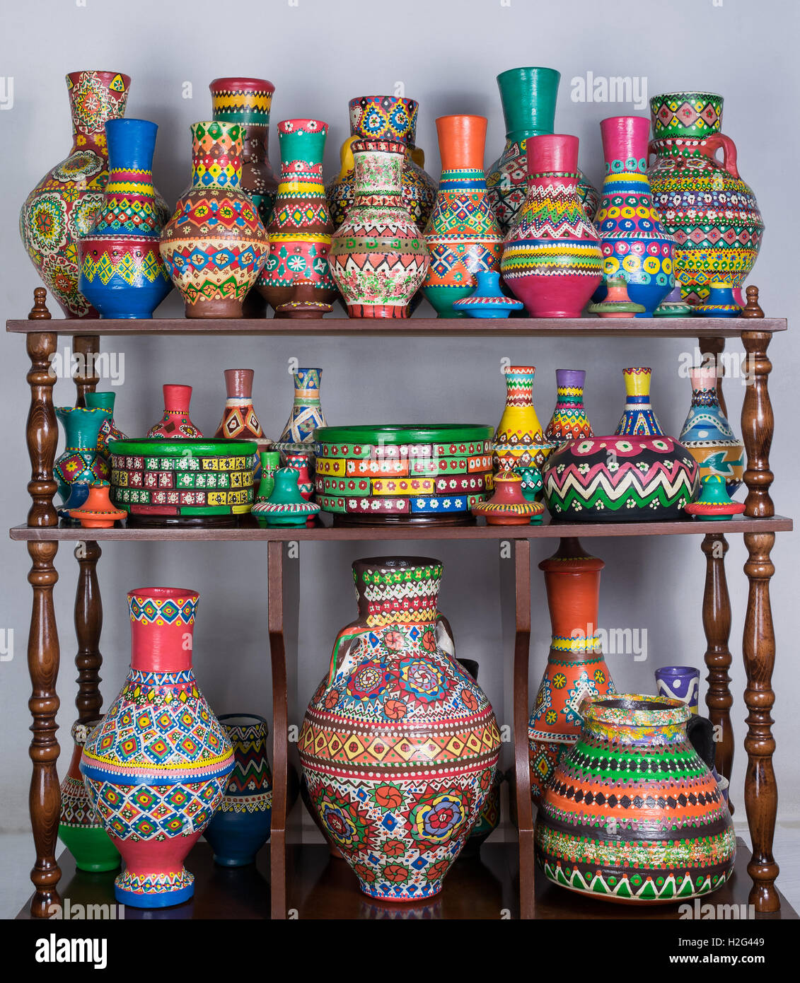 Gruppe von bunt bemalte Keramik Vasen in Holz Regale über weiße Wand  gestapelt Stockfotografie - Alamy