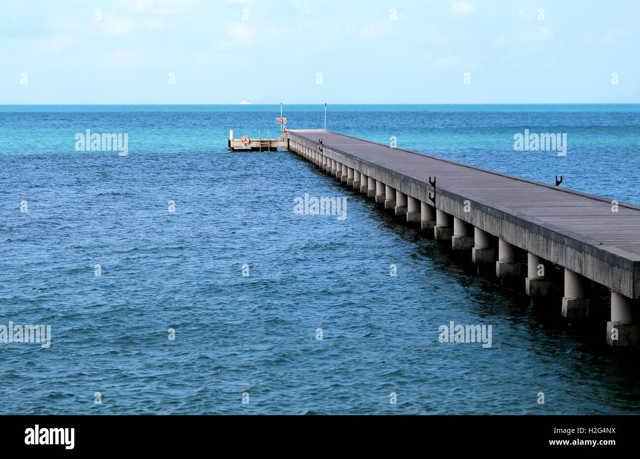 Schöne Mole in ein blaues Meer, fotografiert in Nahaufnahme Stockfoto