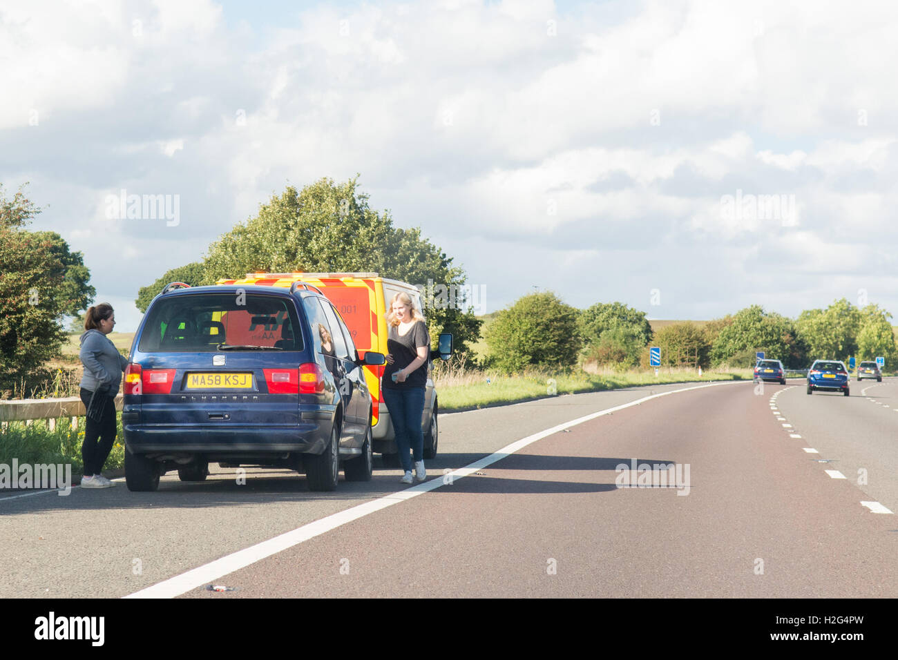 Zwei junge Frauen und Autos auf der Autobahn A1 (m) mit AA van aufgeschlüsselt Stockfoto