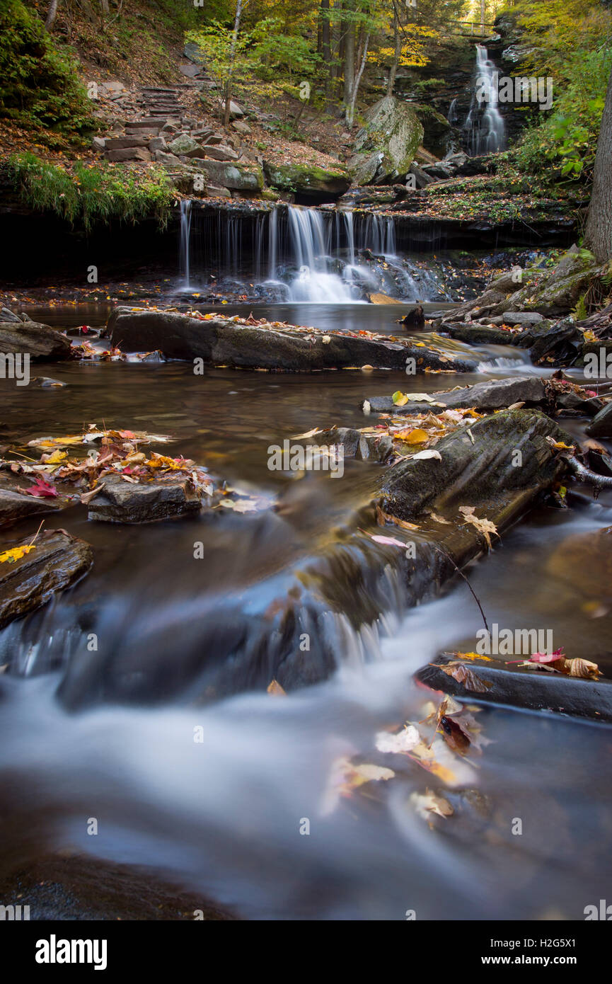 Ein kleiner Wasserfall umgeben von hellen Farben des Herbstes. Stockfoto