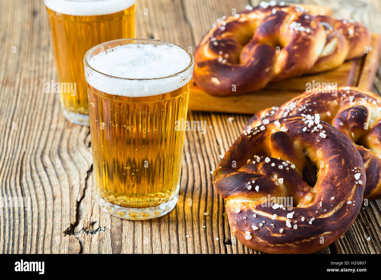 Erfrischendes Bier zu trinken und frische bayerische Brezeln bereit. Traditionelle Speisen und Getränke für deutsche Oktoberfest Stockfoto