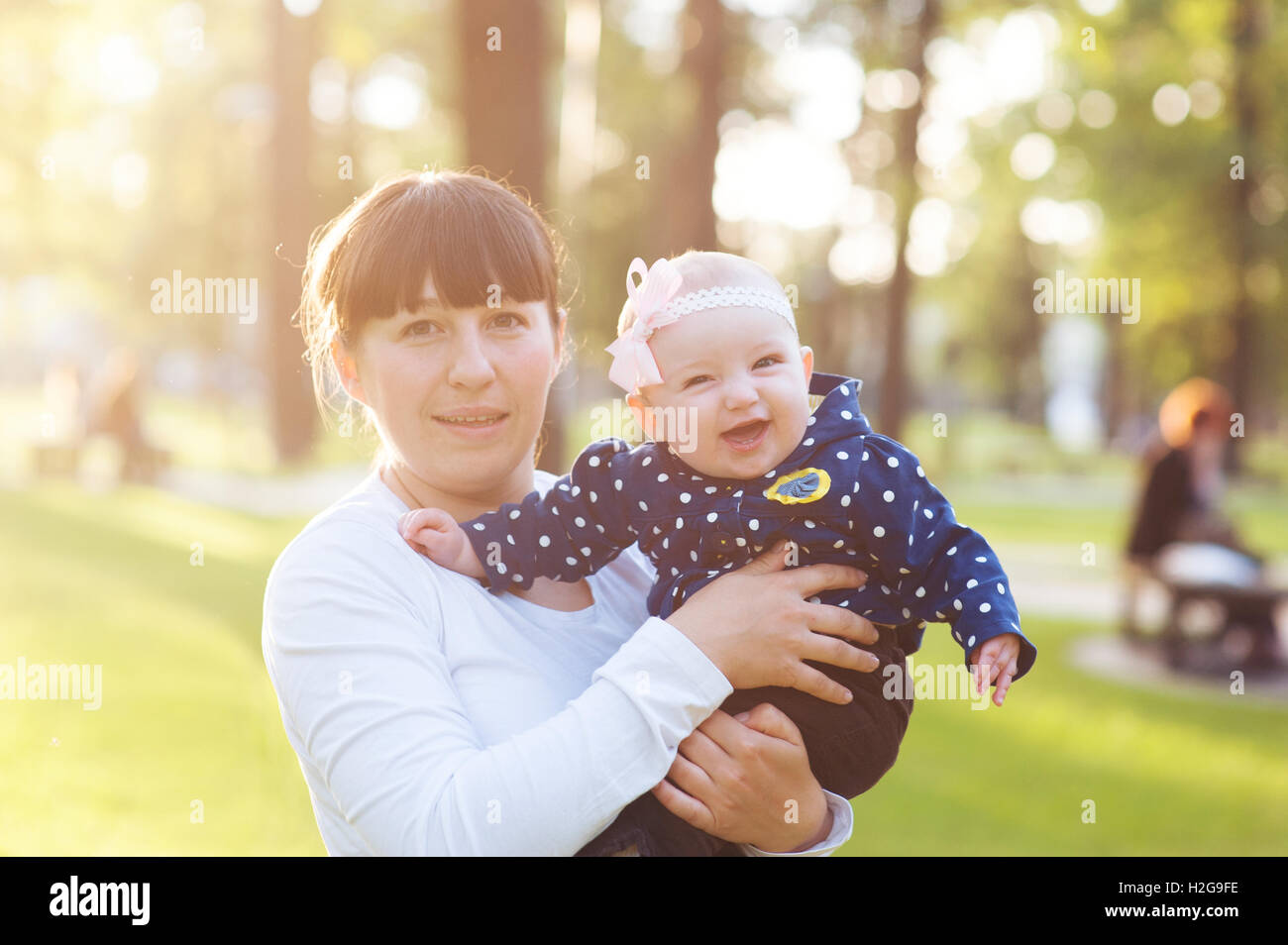 junge Mutter mit einem Babymädchen und Spaziergänge im park Stockfoto