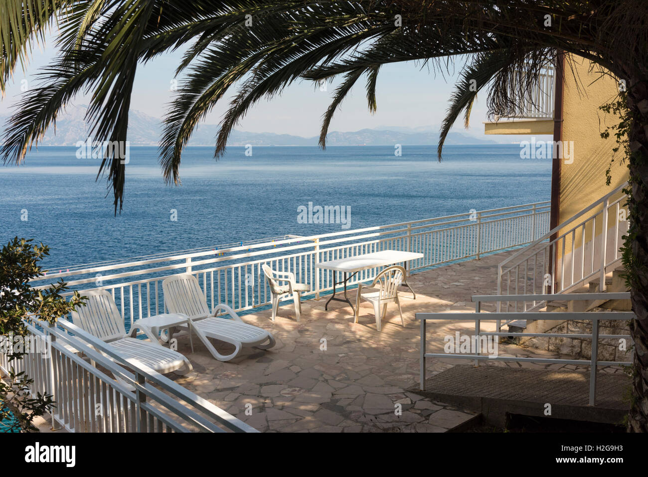 Eine Veranda oder Terrasse mit Liegestühlen und Sonnenliegen von der Adria in Trpanj Kroatien Stockfoto