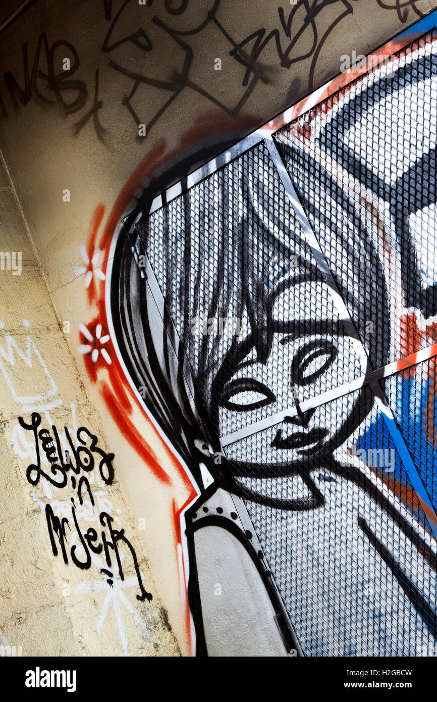 Tags und Graffiti auf eine Betonmauer im Inneren eines Gebäudes Stockfoto