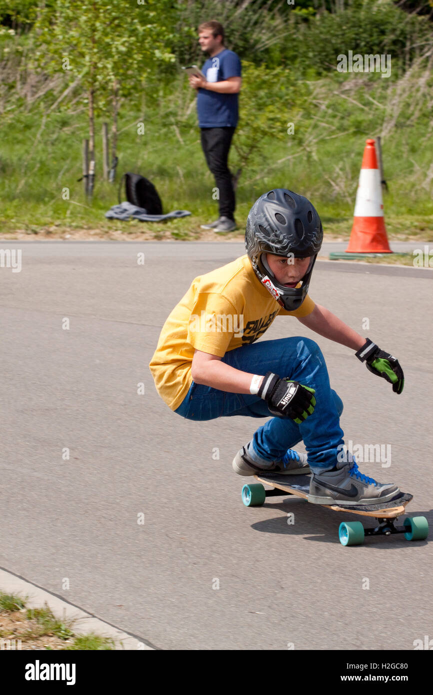 Kleiner Junge Kurven in einem Skateboard-downhill-Rennen Stockfoto