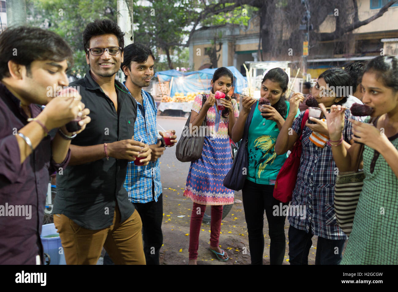 Gruppe von jungen Indianern Essen rasiert Eis auch bekannt als Ice Gola in Hyderabad, Indien Stockfoto