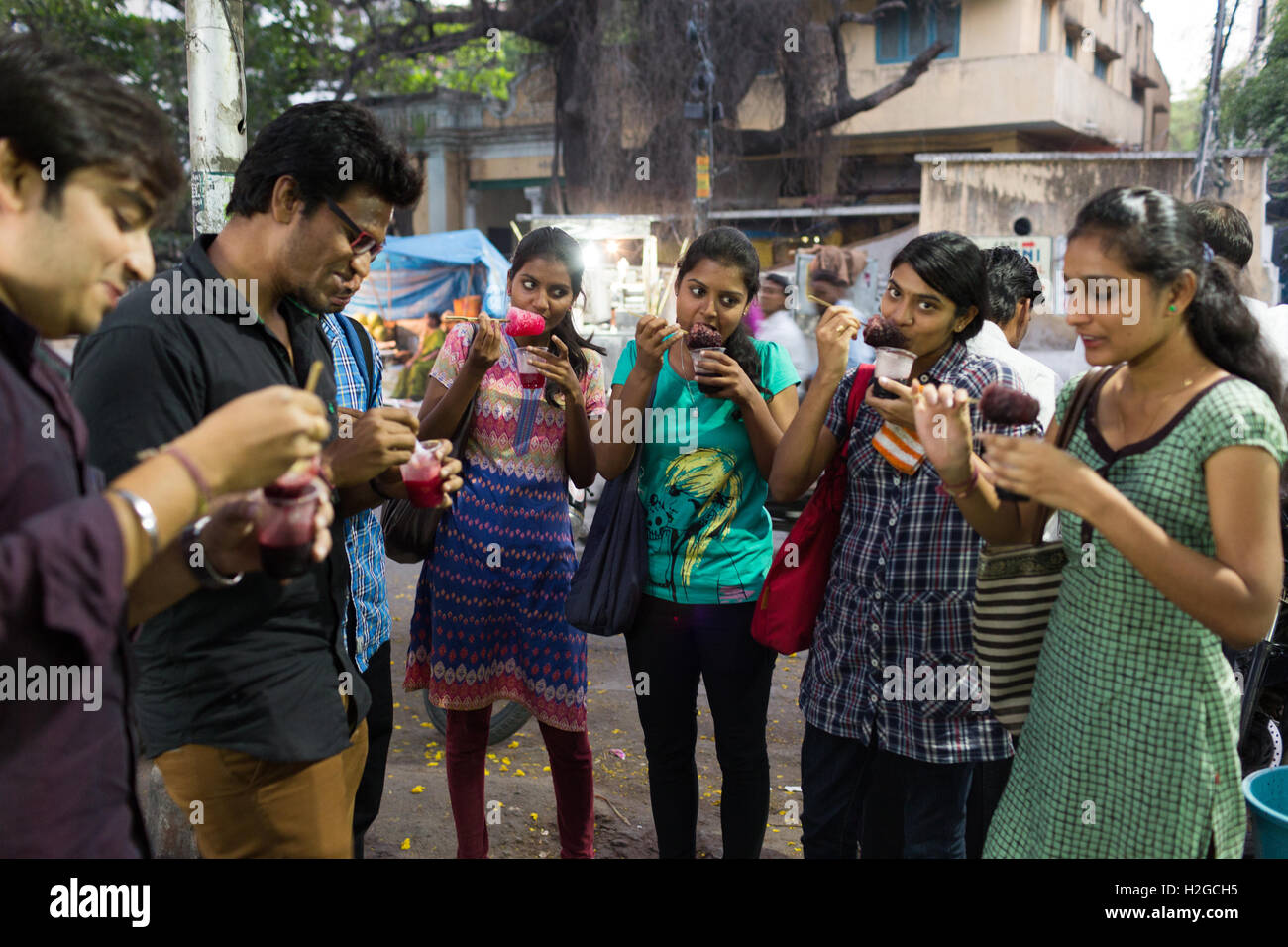 Gruppe von jungen Indianern Essen rasiert Eis auch bekannt als Ice Gola in Hyderabad, Indien Stockfoto