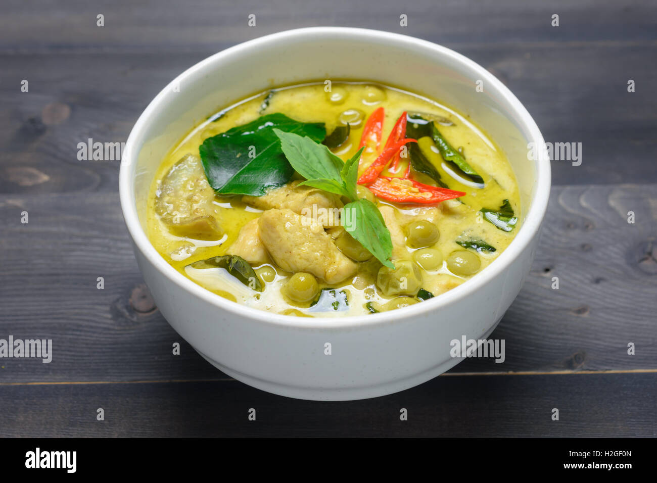 grünes Curry mit Huhn (Kang Keaw Wan Gai) auf hölzernen Hintergrund ...