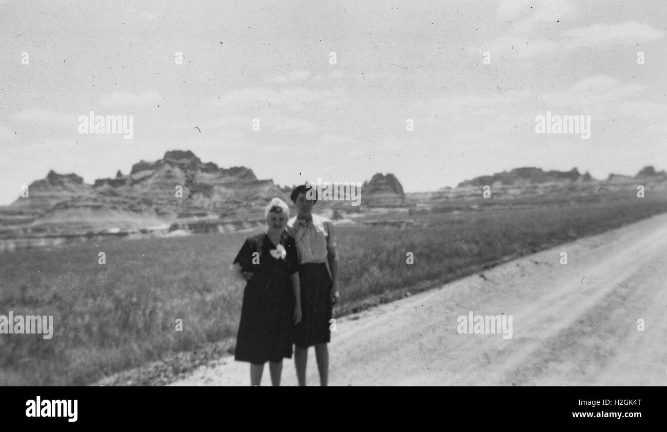 Unbekannte Stadt, USA - 1. Januar 1950: Zwei Frauen stehen in der Nähe einer Straße mit Tafelbergen im Hintergrund, in den Südwesten der USA, 1950 Stockfoto