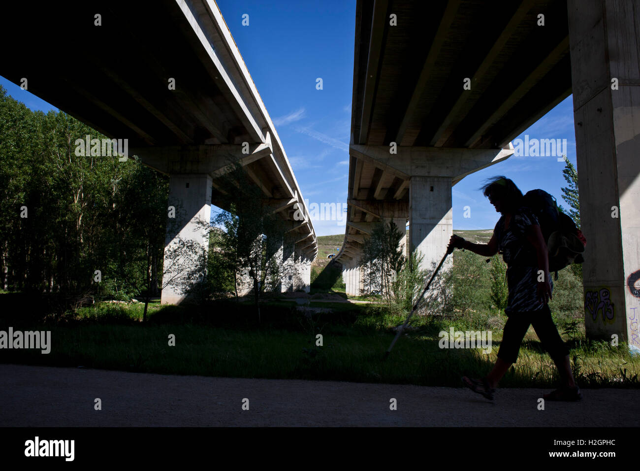 Silhouette eines Pilgers laufen unter einem motor Weg entlang dem Camino de Santiago, route Frances Stockfoto