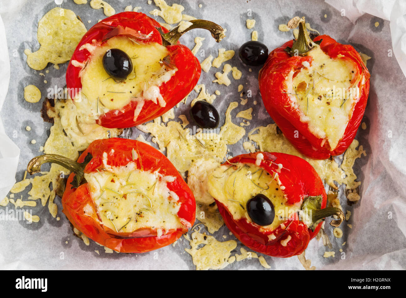 Gefüllte rote Paprika mit Feta-Käse und schwarzen Oliven auf Backblech legen, Ansicht von oben. Stockfoto