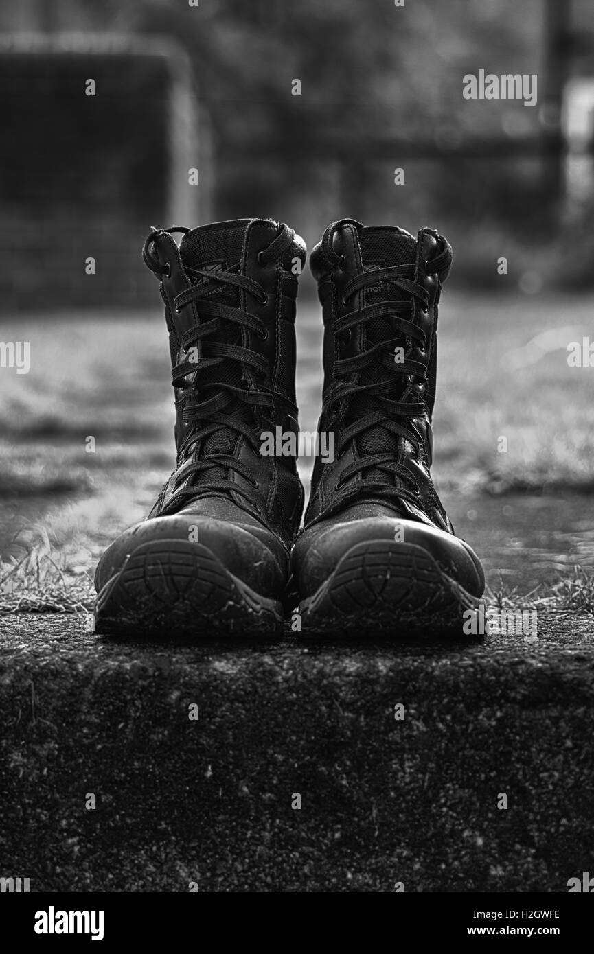 Bergwandern-Stiefel setzte sich auf einen Schritt außerhalb in Schwarzweiß konvertiert Stockfoto