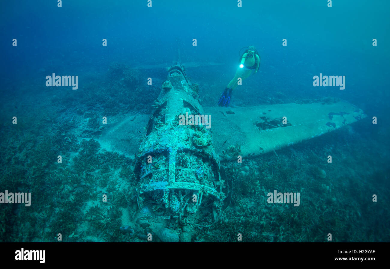 Scuba Diver erforscht eine Grumman F6F Hellcat Flugzeug abgeschossen während des 2. Weltkrieges im Pazifik-Konflikt. Stockfoto
