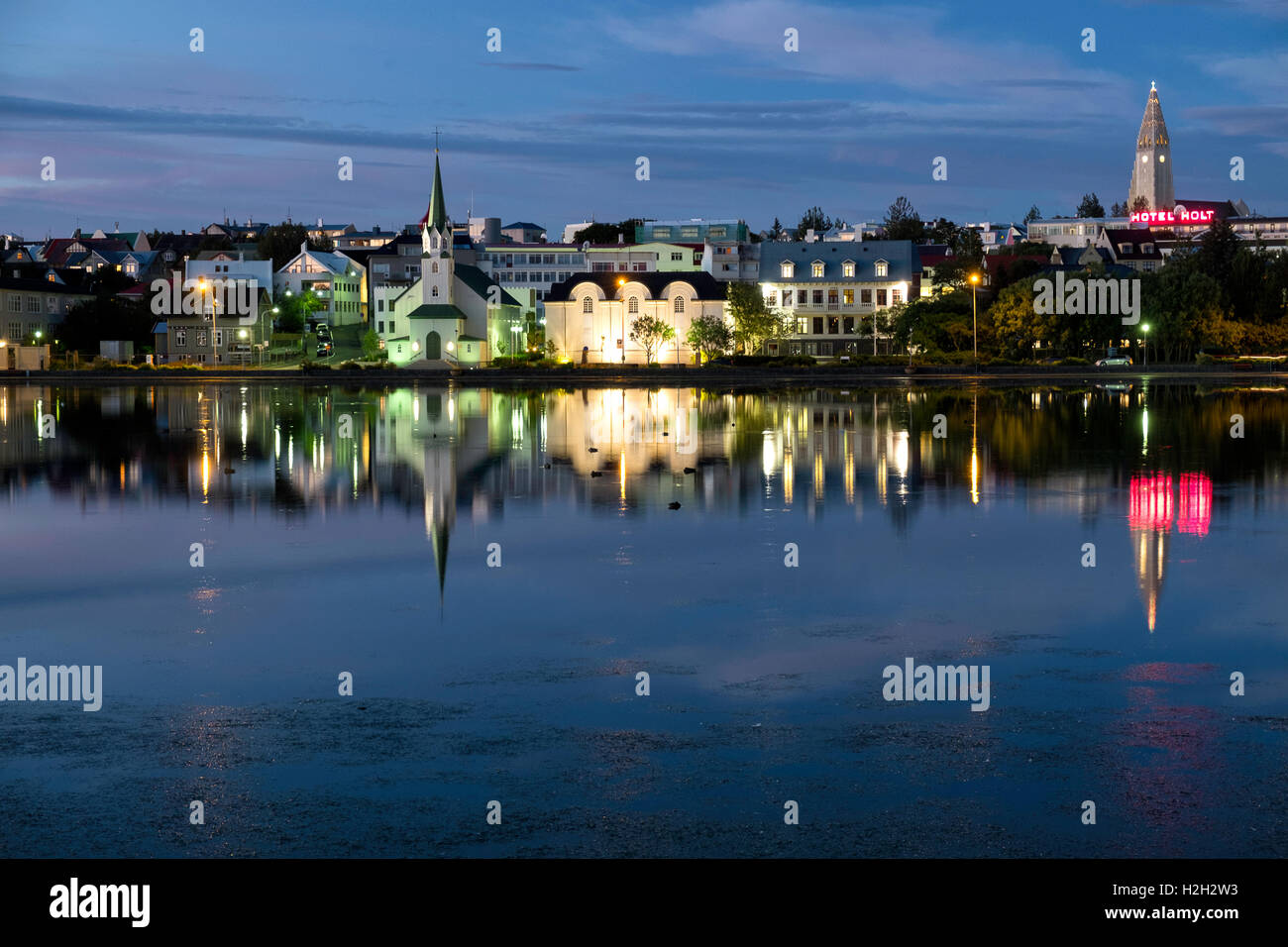 Das Stadtzentrum von Reykjavik Schuß in der Nacht, Reflexionen von Gebäuden in Wasser Stockfoto