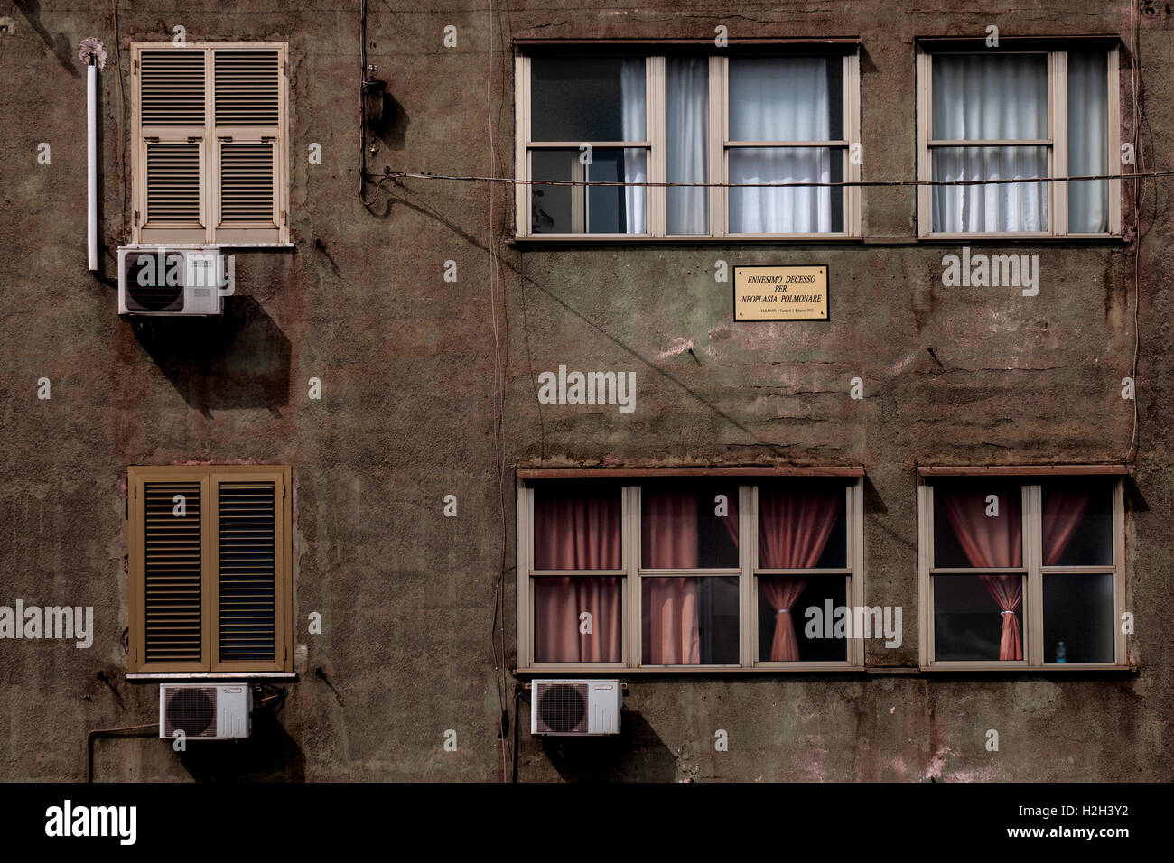 Bezirk von Tamburi, zur Gänze durch die Verschmutzung der Industrien, die in der Mitte der Stadt von Taranto, betreibt s Stockfoto