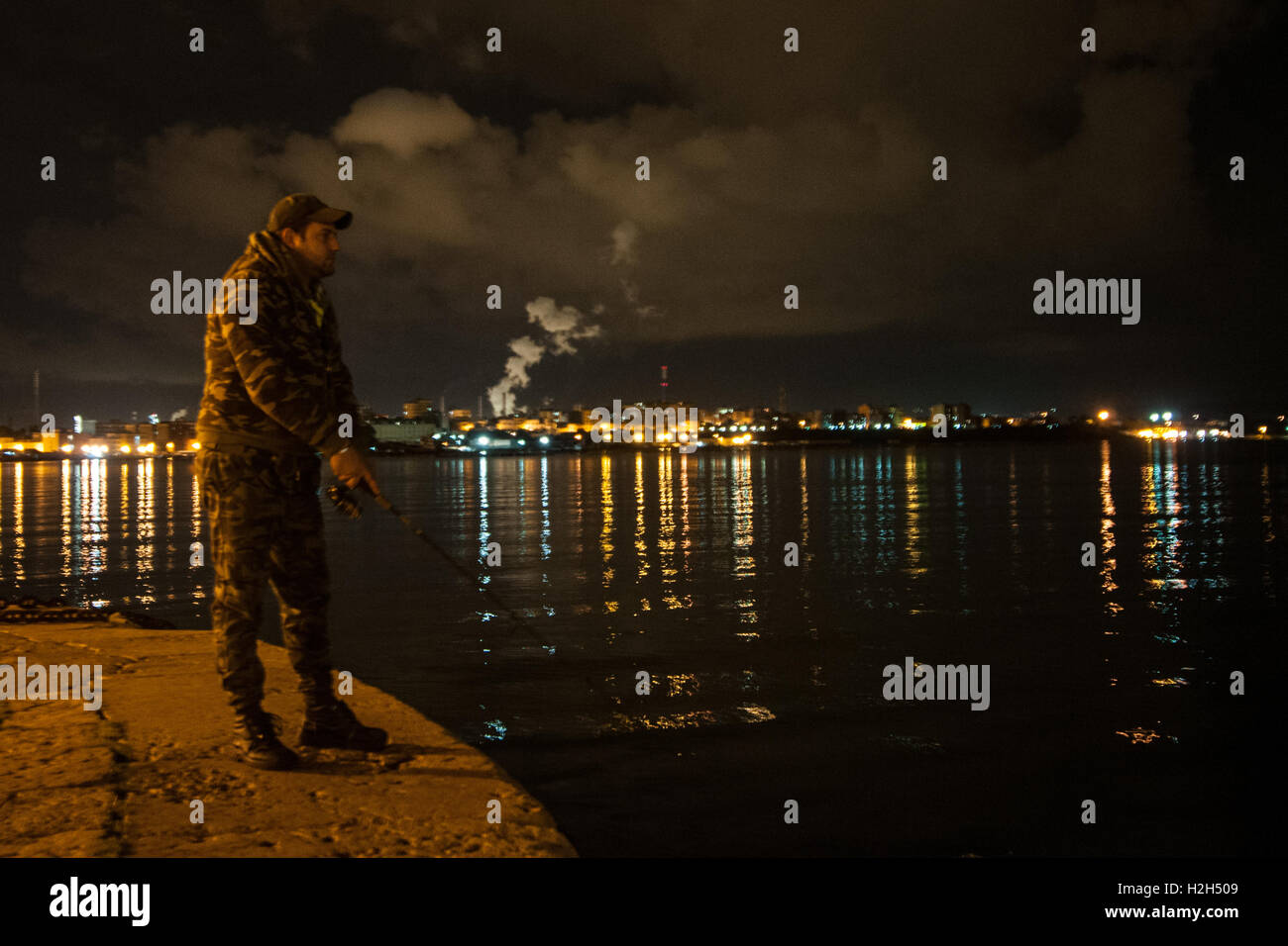 Bürger von Taranto Angeln mit der Verschmutzung auf dem Hintergrund, südlich von Italien. Stockfoto