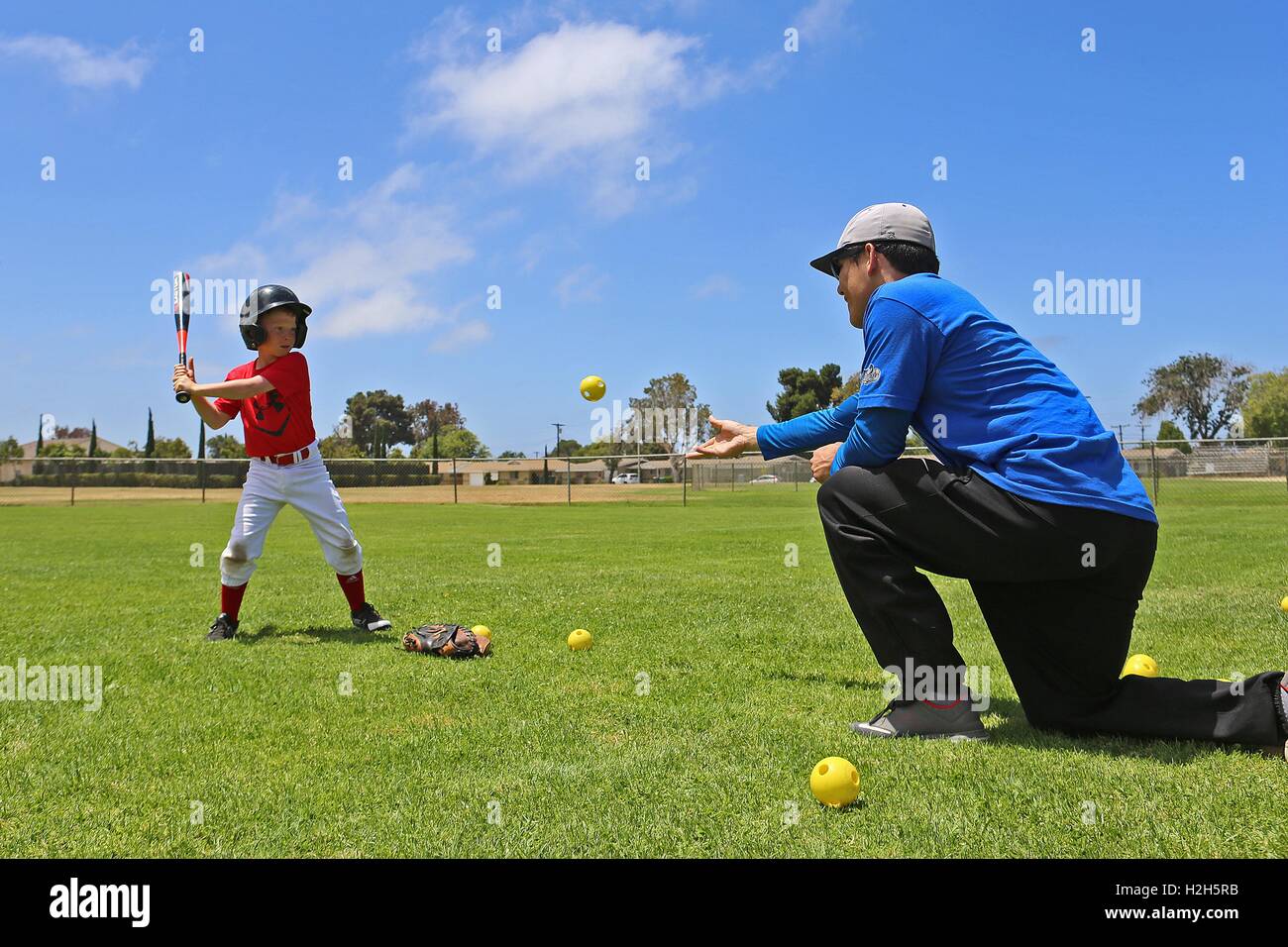 Ein kleiner Junge bereitet, während ein Baseball Sommercamp mit ehemaliger professioneller Baseballspieler Adrian Burnside an den Draht-Berg-Baseball-Feld 12. Juli 2016 in Camp Pendleton, Kalifornien auf einem Ball zu schwingen. Stockfoto