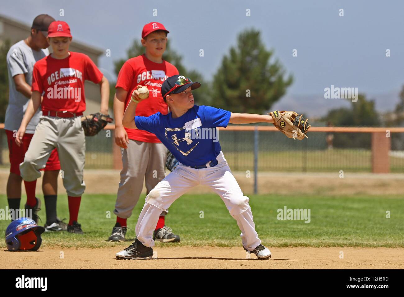 Ein kleiner Junge bereitet sich auf einen Ball während einer Sommer-Baseball-Camp mit ehemaliger professioneller Baseballspieler Adrian Burnside an den Draht-Berg-Baseball-Feld 12. Juli 2016 in Camp Pendleton, Kalifornien werfen. Stockfoto