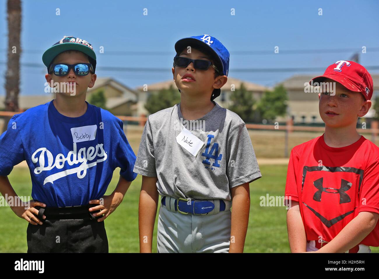 Jungen tragen offiziellen MLB Teambekleidung stehen und warten nach dem Weg während einer Sommer Baseball Camp mit ehemaliger professioneller Baseballspieler Adrian Burnside an den Draht-Berg-Baseball-Feld 12. Juli 2016 in Camp Pendleton, Kalifornien. Stockfoto