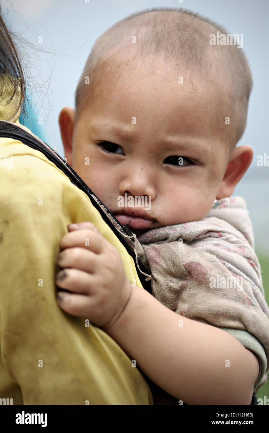 Porträt eines Babys auf dem Rücken ihrer Schwester in der Provinz Ha Giang, Nord-Vietnam Stockfoto