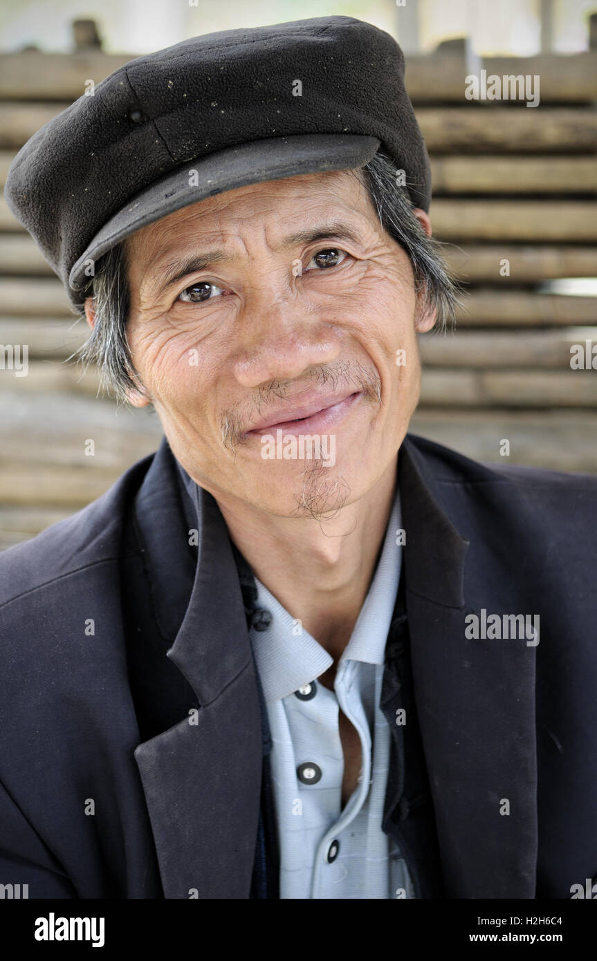 Porträt von ein lächelnder Mann mit einer Kappe auf dem Quyet Tien-Markt in Ha Giang Provinz, Nord-Vietnam Stockfoto