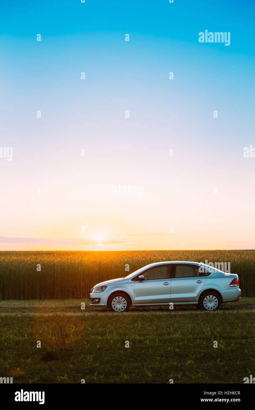 Gomel, Weißrussland - 6. Juni 2016: Volkswagen Polo Parkplatz am Weizenfeld. Sonnenuntergang Sonnenaufgang dramatischer Himmel auf einem Hintergrund In sonniger Stockfoto