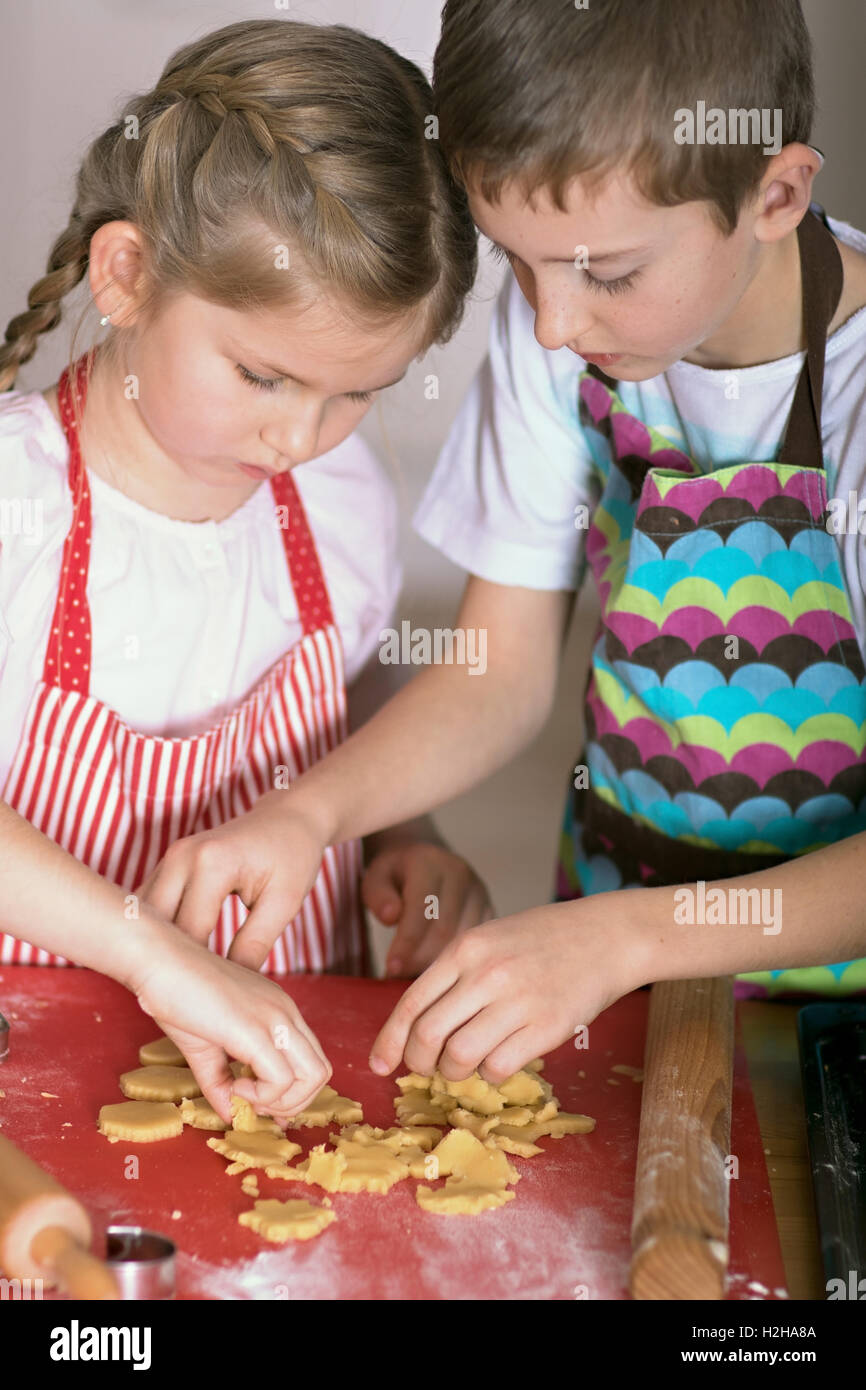 Mädchen und jungen Schnittformen der Verknüpfung Backwaren Herstellung Kekse Stockfoto
