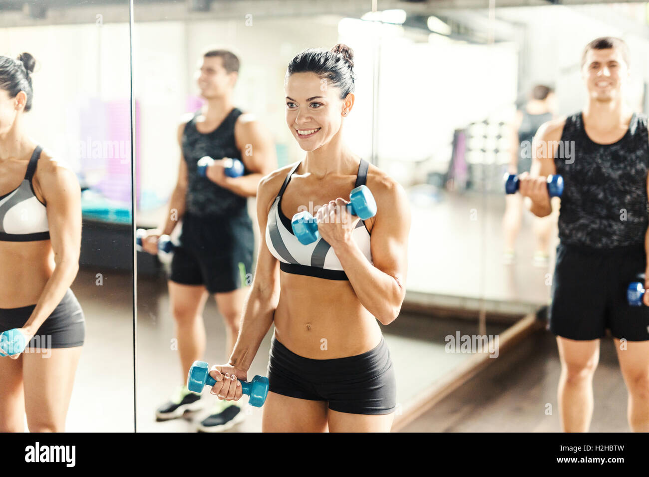 Energetische sportliches Girl das Training mit Hanteln im Fitnessstudio Stockfoto
