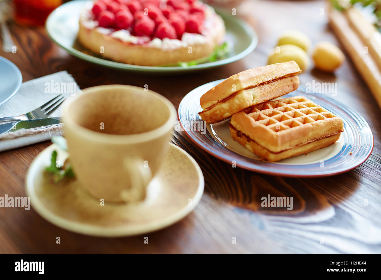 Süßer snack auf Teller und eine Tasse Tee oder Kaffee am Tisch Stockfoto