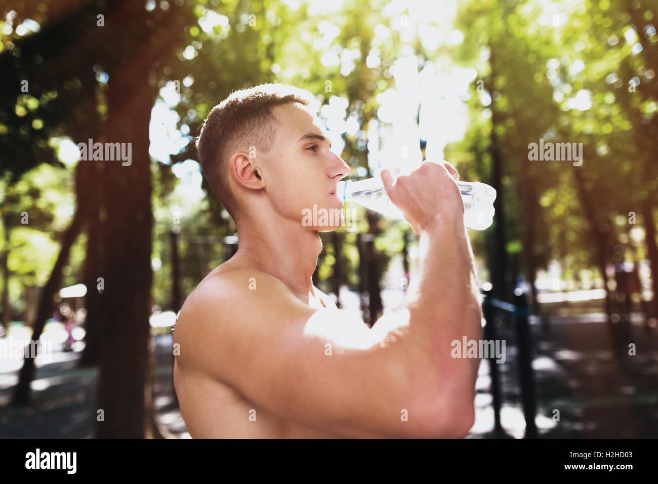 Athletische Sportart Man Trinkwasser aus der Flasche. Outdoor-Fitness. Stockfoto