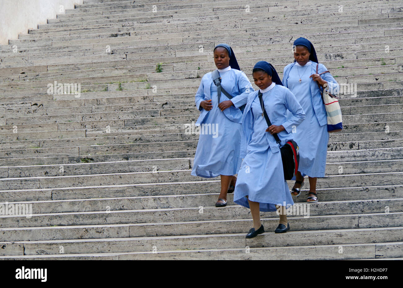 Drei afrikanische Nonnen in den Himmel-blau Gewohnheiten und Dunkel blaue Schleier zu Fuß über eine Treppe neben dem Quirinal in Rom. Stockfoto