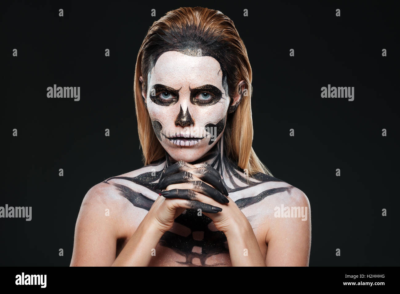 Frau mit erschreckend Skelett Make-up auf schwarzem Hintergrund Stockfoto