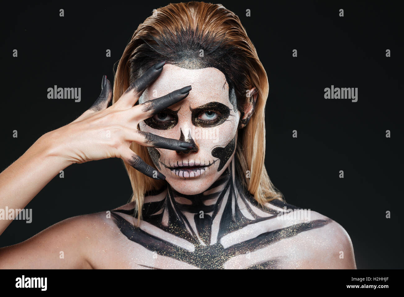 Frau mit furchterregenden Halloween Make-up auf schwarzem Hintergrund Stockfoto