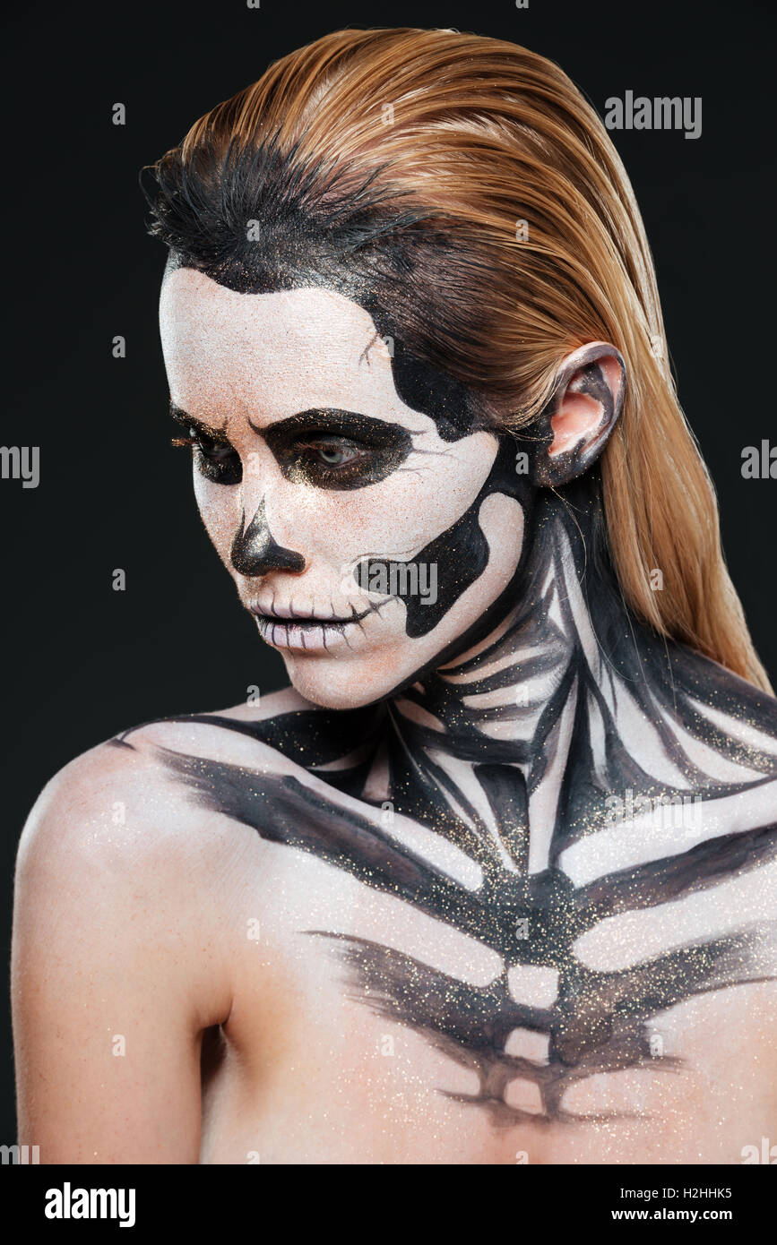 Frau mit erschreckenden Angst Make-up auf schwarzem Hintergrund Stockfoto