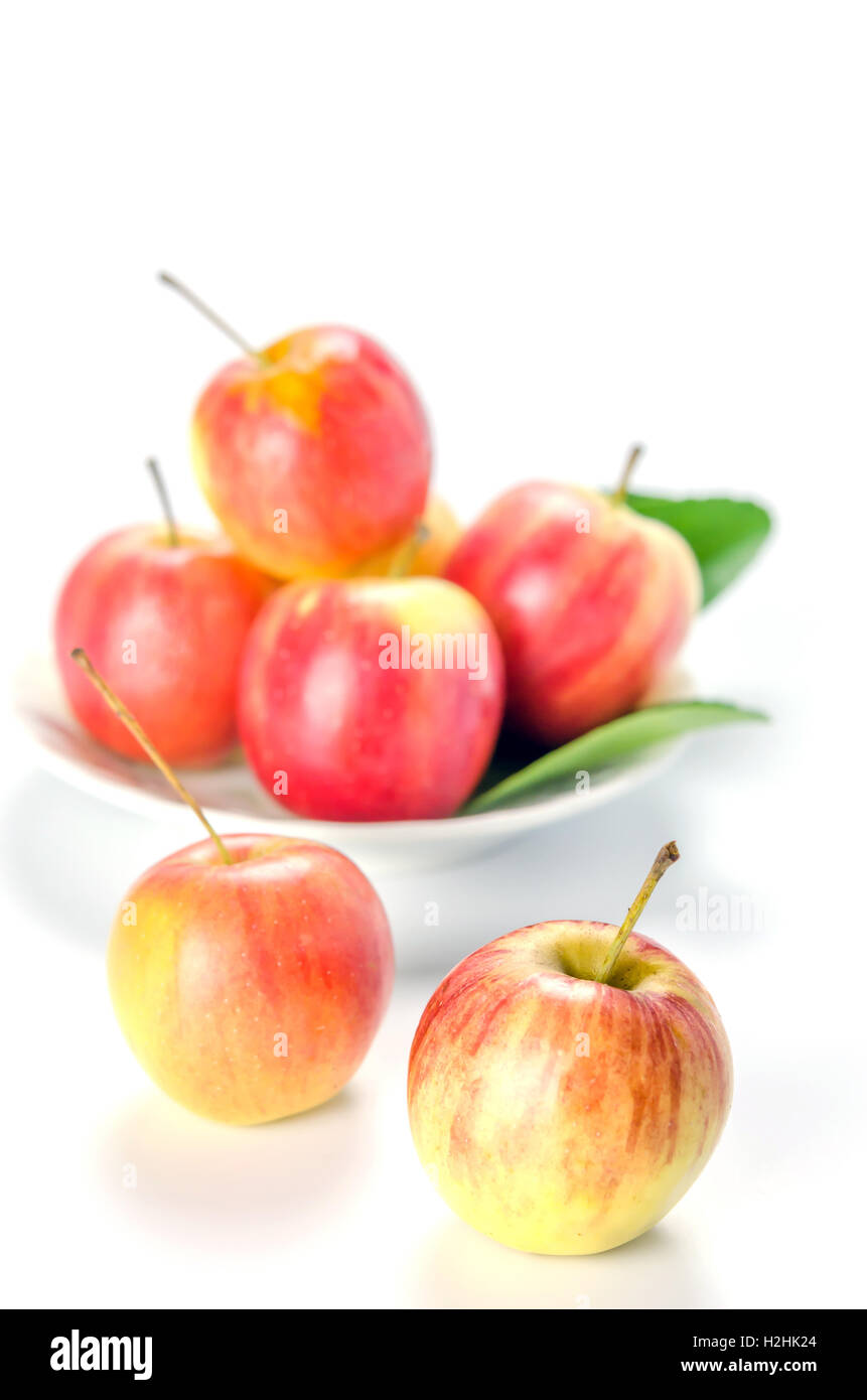 Rote und gelbe Apfel mit Schüssel weiß, frisches Bio-Obst Stockfoto