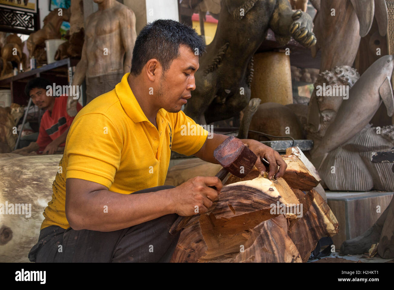 Indonesien, Bali, Mas, Holzschnitzerei, Handwerker in am Straßenrand Werkstatt schnitzen Stockfoto