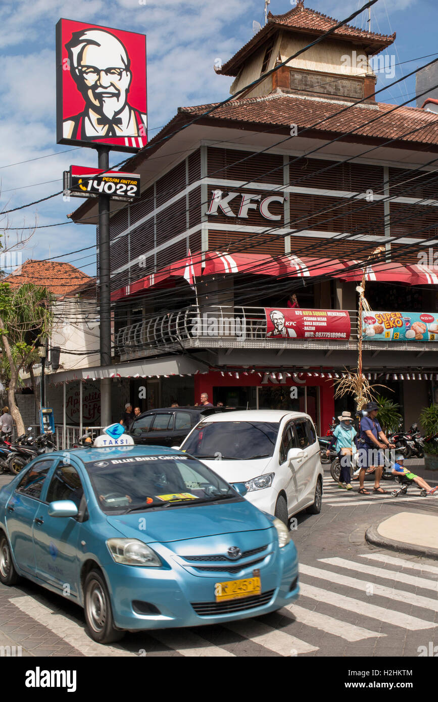 Indonesien, Bali, Kuta, Jalan Pantai Kuta, Bluebird taxi vorbei Kentucky Fried Chicken-Fast-Food-shop Stockfoto