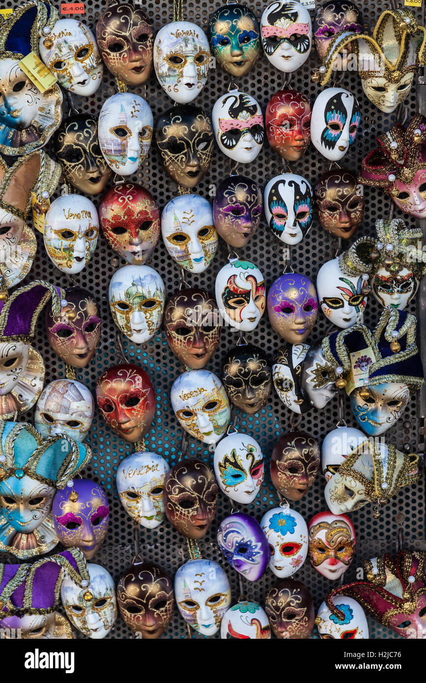 Miniatur-Masken, in wunderschönen Farben sind in einer Gruppe auf ein Brett, für den Verkauf an Touristen in Venedig, Italien angeheftet. Stockfoto