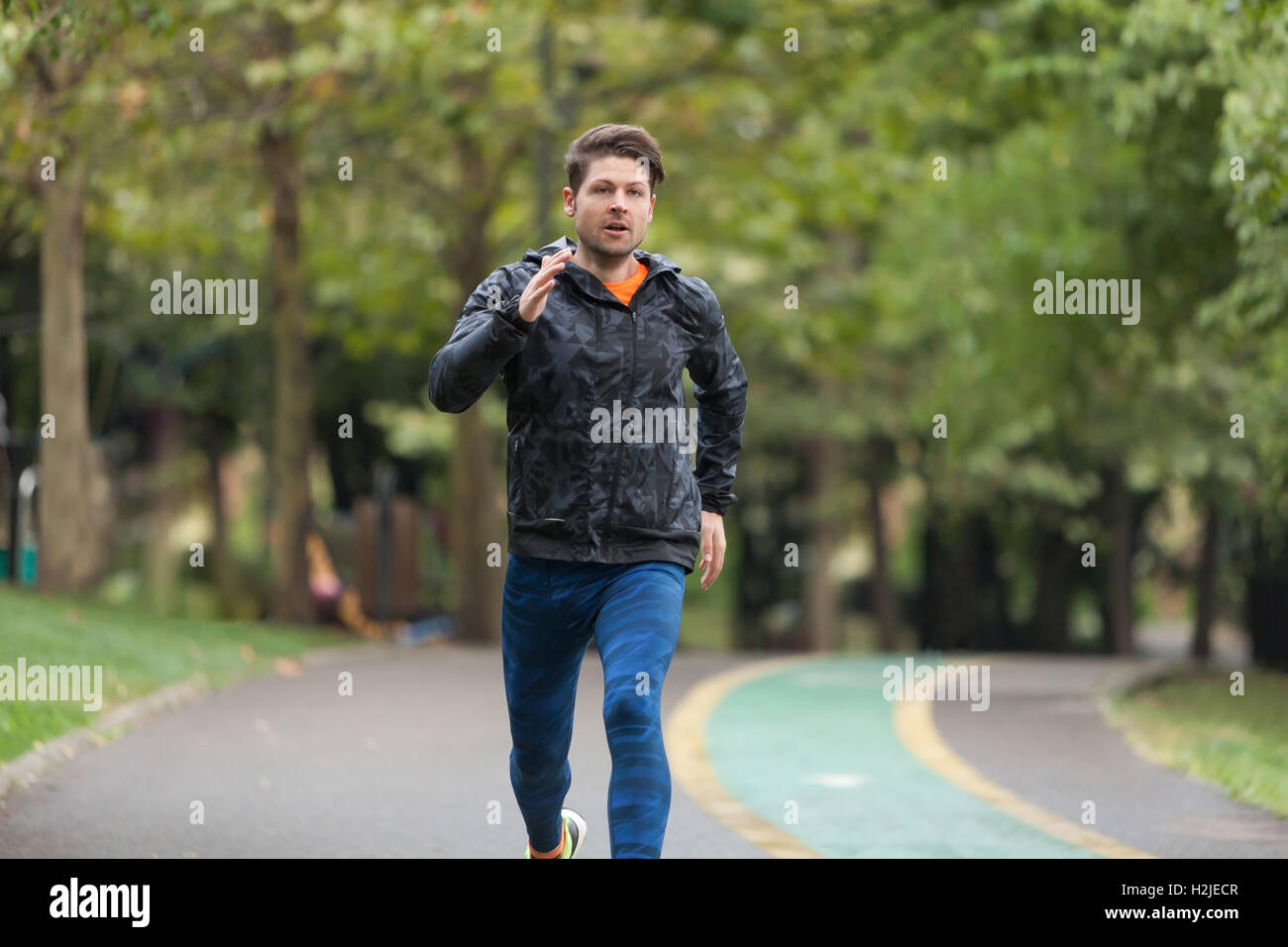 Sportlicher Mann läuft an einem regnerischen Tag. Stockfoto