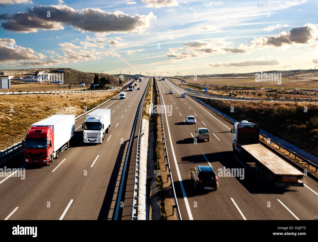 Internationaler Versand, Lastwagen und Autos fahren auf der Straße. Logistik und Lagerhaltung Stockfoto