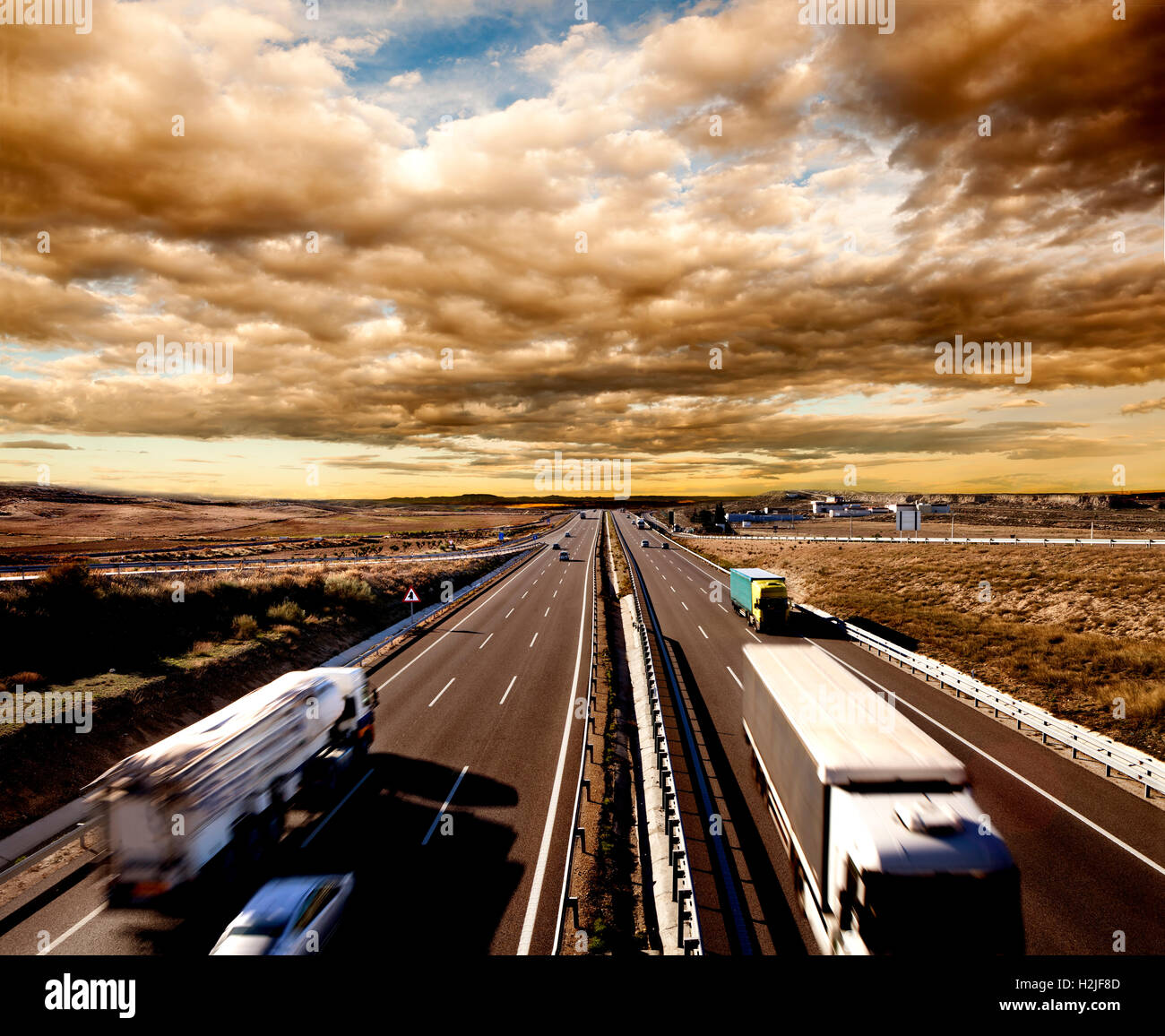 Internationaler Versand, Lastwagen und Autos fahren auf der Autobahn. Logistik und Lagerhaltung Stockfoto