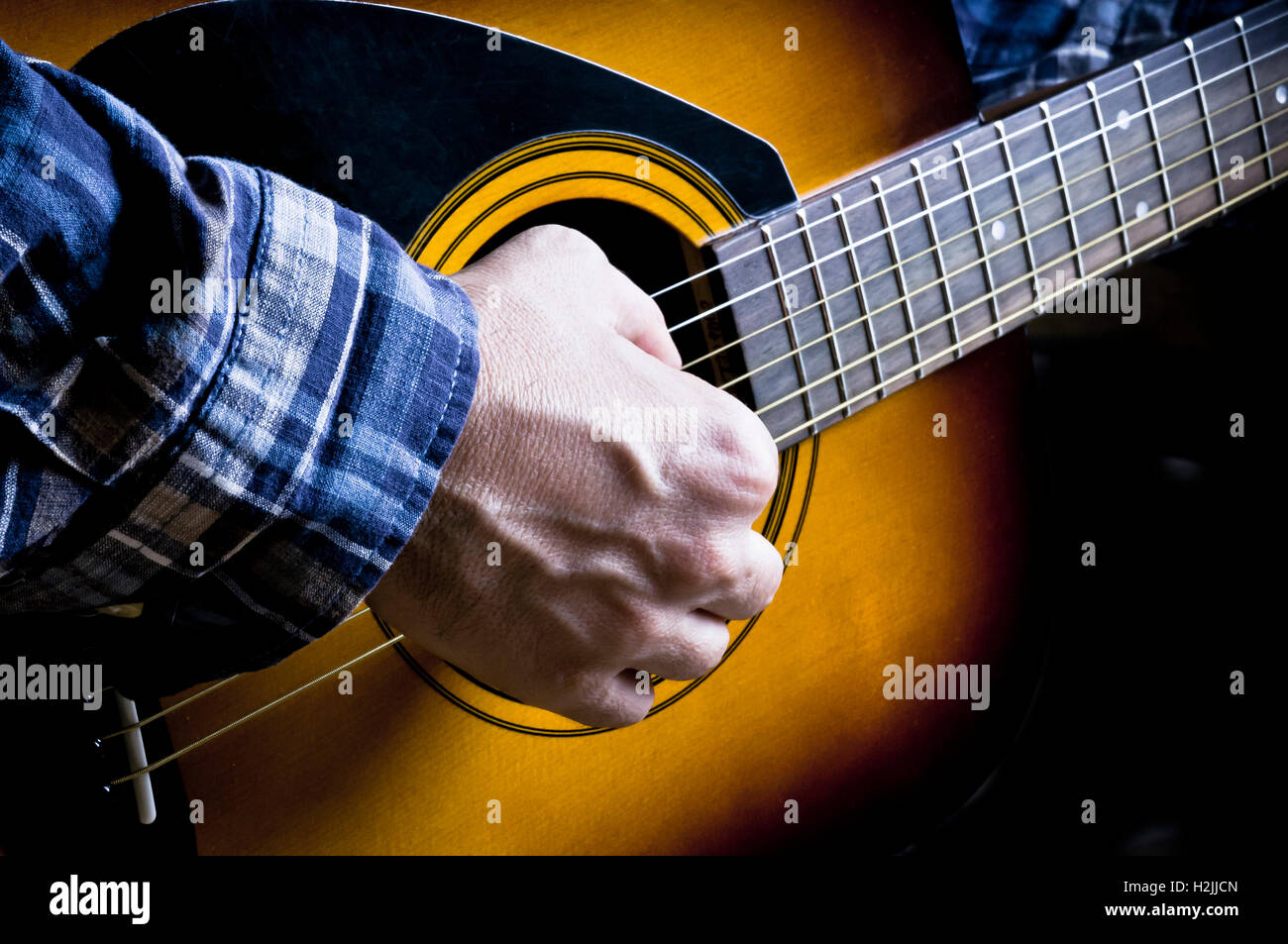 männliche Gitarrist spielt eine akustische Gitarre Stockfoto