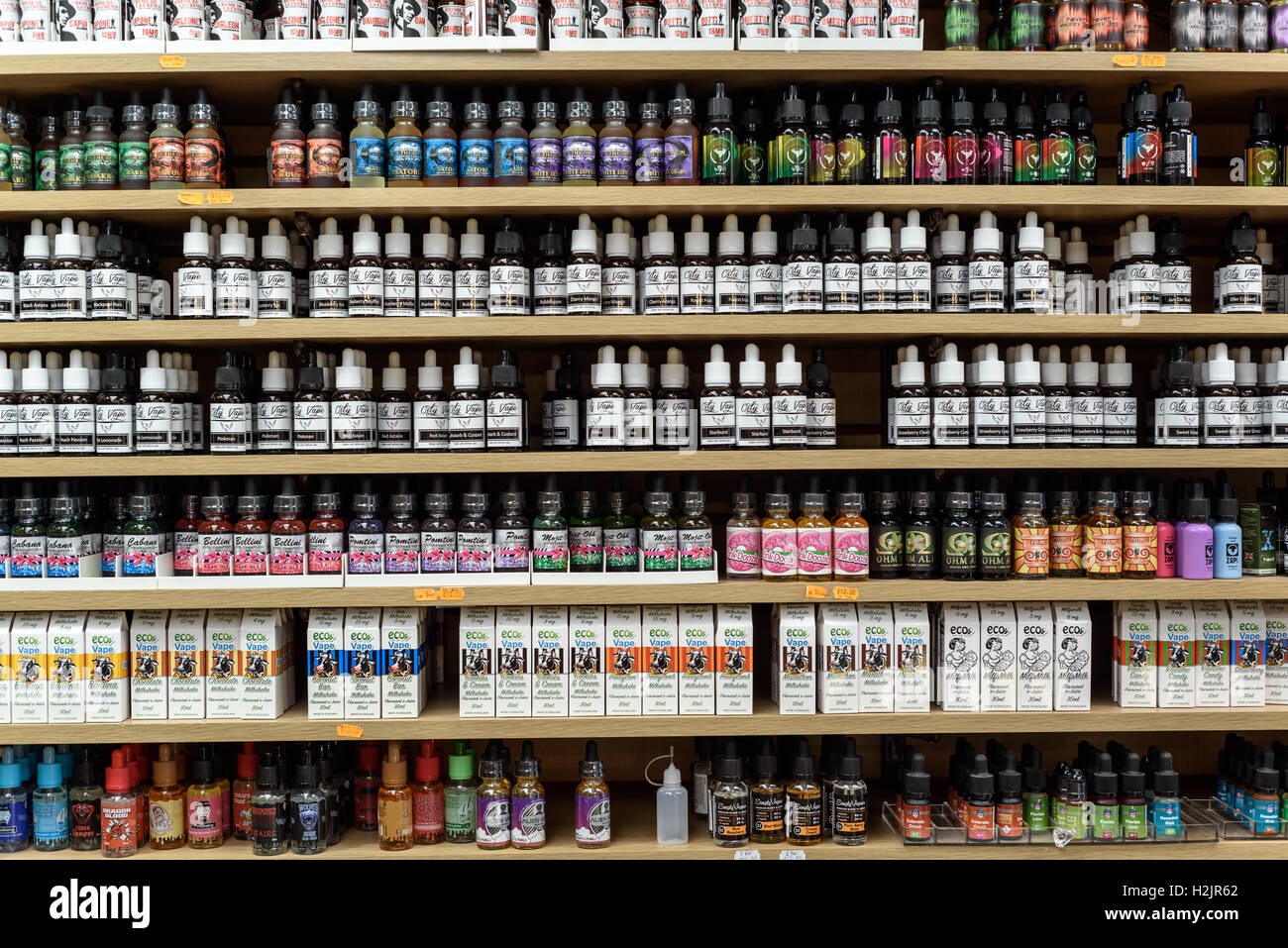 Reihen von Flaschen von Flüssigkeiten in verschiedenen Geschmacksrichtungen für Dampfen und Dämpfe auf dem Display in einem Geschäft Stockfoto