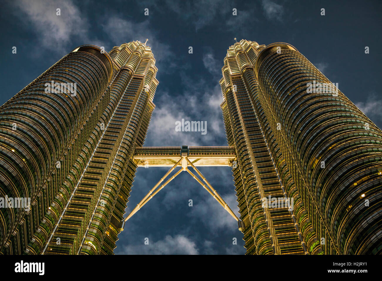 Die Petronas Twin Towers und Skybridge leuchten am späten Nachmittag in der Innenstadt von Kuala Lumpur, Malaysia, in goldener Farbe. Stockfoto