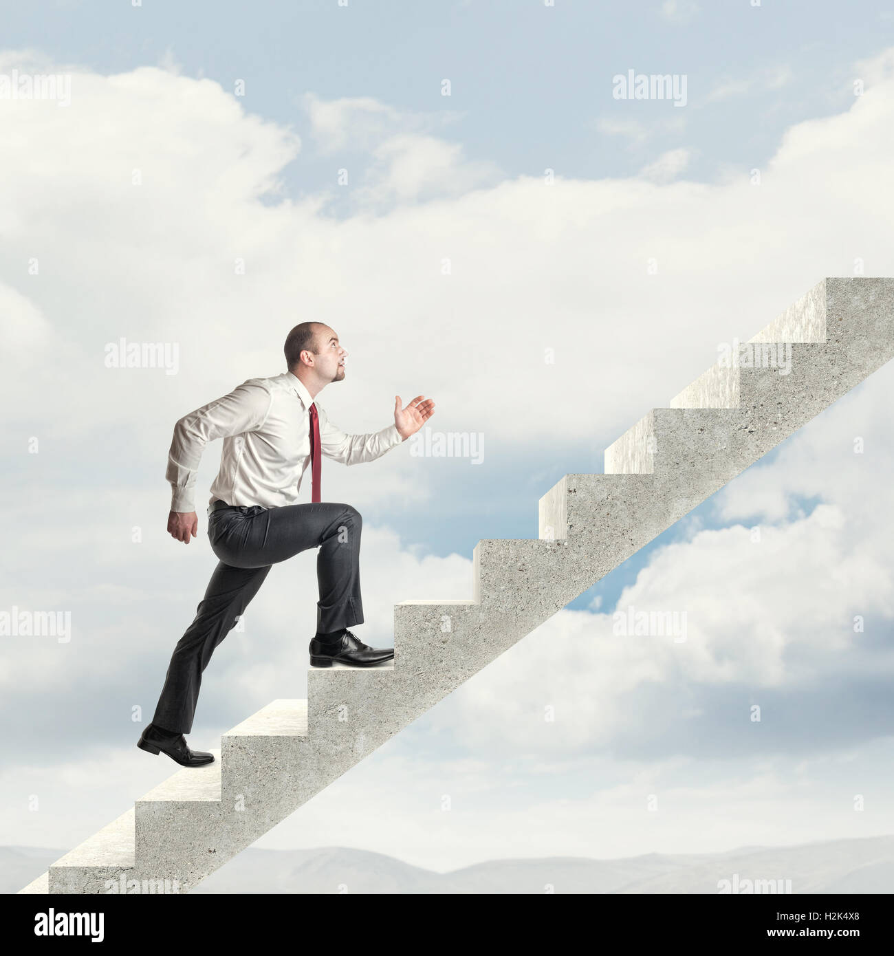 Geschäftsmann auf Beton Treppe in den Himmel steigen Stockfoto