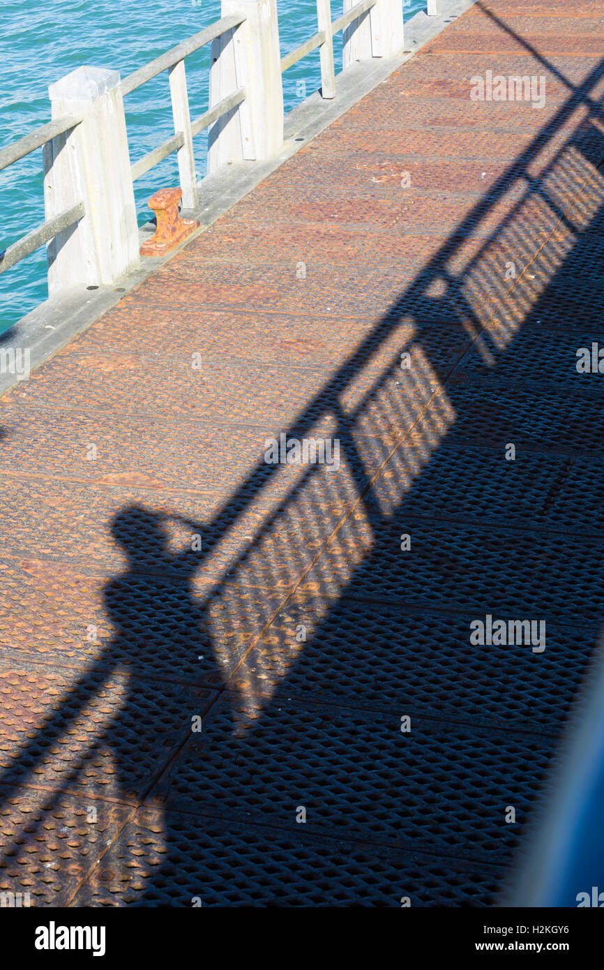 Schatten der Figur durch Geländer auf Bournemouth Pier im September Stockfoto