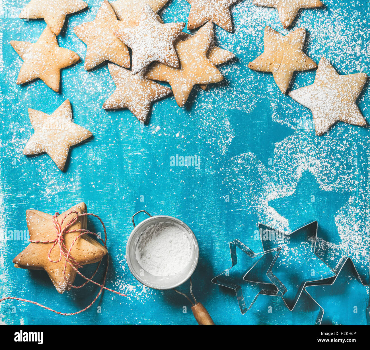 Weihnachten oder Silvester Urlaub Essen Hintergrund. Süße Lebkuchen in Form eines Sterns mit Zuckerpuder auf leuchtend blaue Farbe Stockfoto